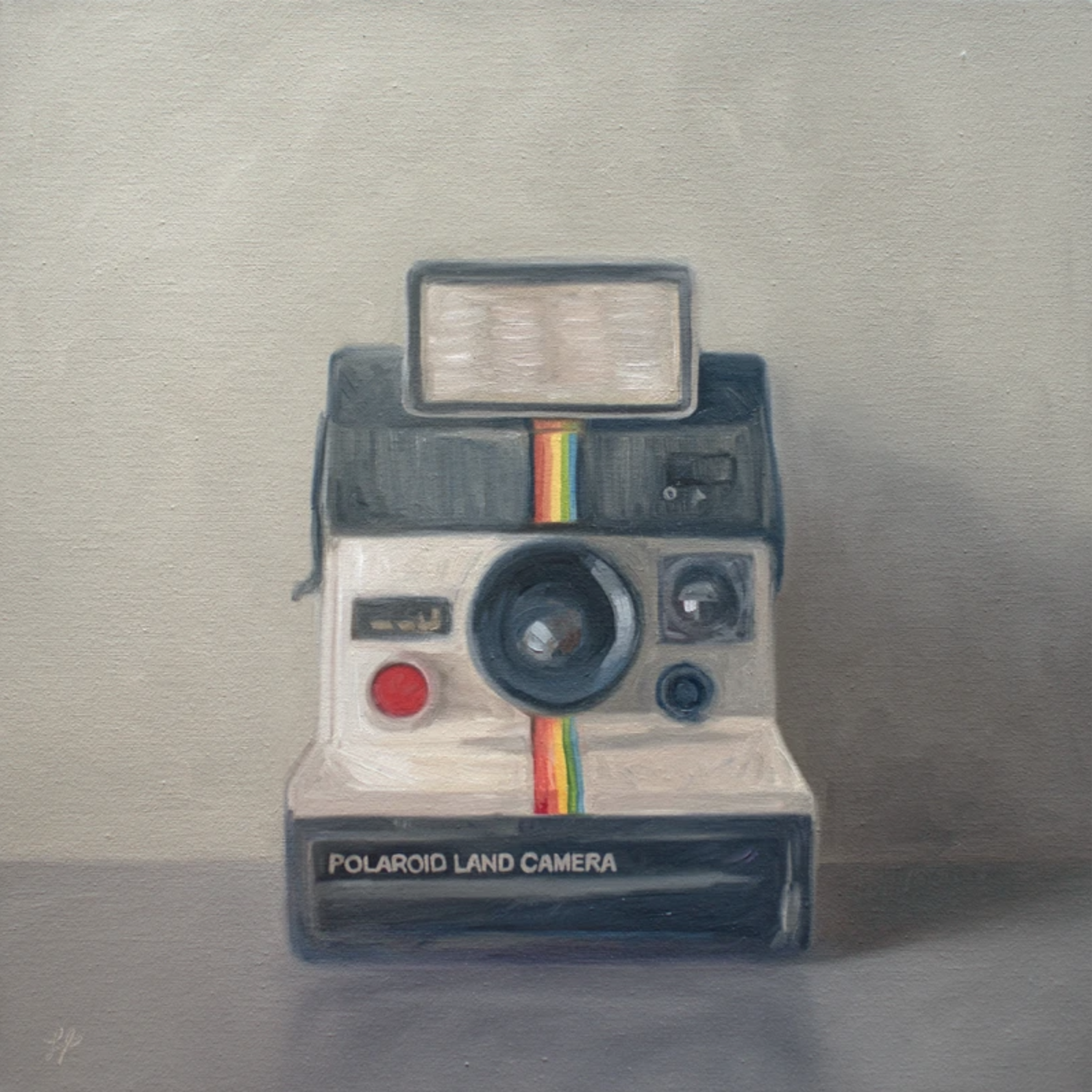 A vintage Polaroid camera rests on a grey surface with a light warm grey background.
